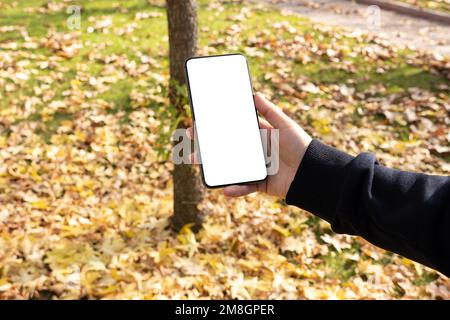 Over shoulder view of woman holding smartphone mock up. White blank screen for adding video call, browsing media, application design. Stock Photo