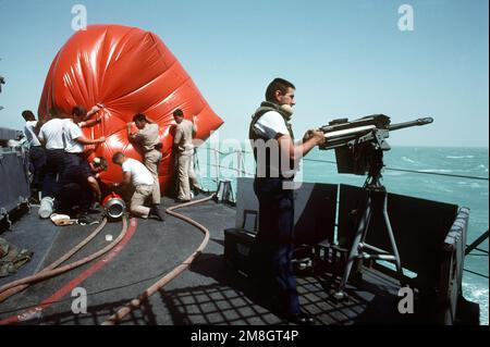 GUNNER's Mate 1ST Class Bradley Chamberlain mans an Mk 19, Mod 3, 40mm automatic grenade launcher for gunnery practice on the frigate USS FANNING (FF-1076) during exercise Eager Sentry 92-4. The crewmen in the background are preparing to deploy an inflatable gunnery target. Subject Operation/Series: EAGER SENTRY 92-4 Country: Unknown Stock Photo