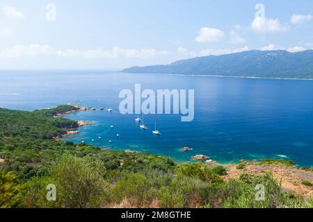 Corsica island on a sunny day, Cupabia gulf. Summer landscape with pleasure boats anchored near rocky coast Stock Photo