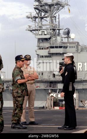 Journalist SEAMAN Eddie Pagan, Navy Broadcasting Detachment, Rota, interviews ADM Jeremy M. Boorda, commander in chief, U.S. Naval Forces, Europe/Allied Forces, southern Europe, as the admiral visits aboard the dock landing ship USS GUNSTON HALL (LSD-44). The island of the Spanish aircraft carrier SPS PRINCIPE DE ASTURIAS (R-11) is in the background. Base: Naval Station, Rota Country: Spain (ESP) Stock Photo