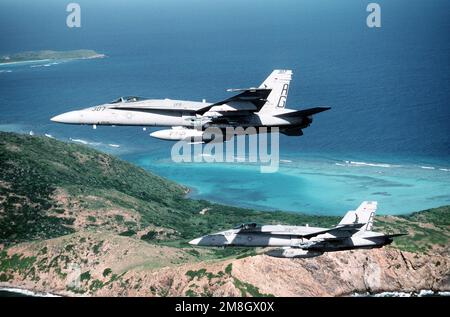 An air-to-air left side view of two Strike Fighter Squadron 136 (VFA-136) F/A-18C Hornet aircraft near Naval Station, Roosevelt Roads. State: Puerto Rico (PR) Country: United States Of America (USA) Stock Photo