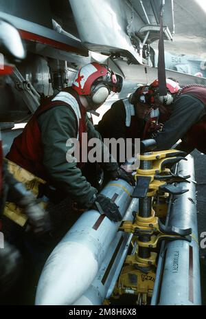 Aviation ordnancemen prepare to mount an AIM-7 Sparrow air-to-air missile on a wing pylon of a Fighter Squadron 32 (VF-32) F-14A Tomcat aircraft on the aircraft carrier USS JOHN F. KENNEDY (CV-67). Country: Adriatic Sea Stock Photo