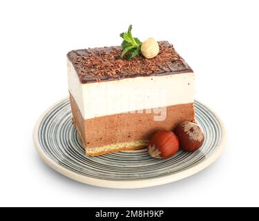 Plate with piece of birds milk cake, hazelnuts and mint leaves on white background Stock Photo