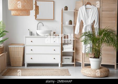 Interior of bathroom with ceramic sink, drawers and folding screen Stock Photo