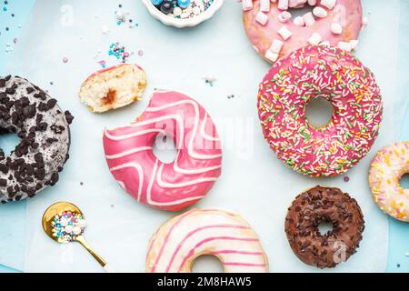 Parchment with different delicious donuts on blue background Stock Photo