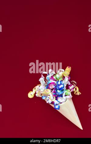 Paper cone with colorful party streamers Viva Magenta background.  Stock Photo