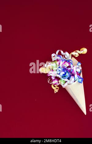 Paper cone with colorful party streamers Viva Magenta background.  Stock Photo