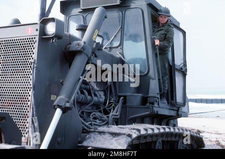 Equipment Operator Construction Apprentice Miller climbs operates a bulldozer during a causeway-building exercise with Amphibious Construction Battalion 1 (ACB-1). Base: Naval Amphibious Base, Coronado State: California (CA) Country: United States Of America (USA) Stock Photo