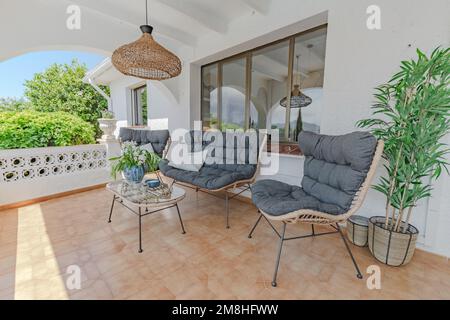 a Mediterranean garden terrace view of a small table and set of chairs to enjoy the views Stock Photo