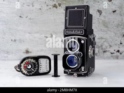 Vintage 1950's Rolleiflex TRL Camera accompanied with a vintage Weston Master III Light meter, and empty roll film cartridge. Stock Photo