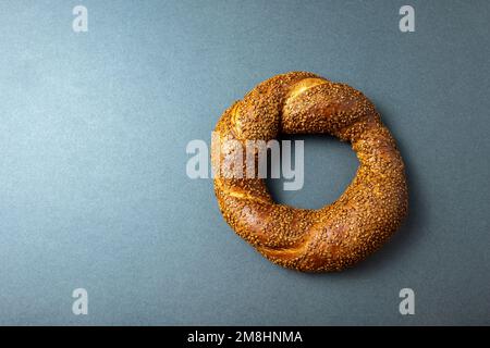Fresh soft baked sesame bagel on dark background. Stock Photo