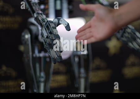 Businessman hand shaking hands with robot droid Stock Photo