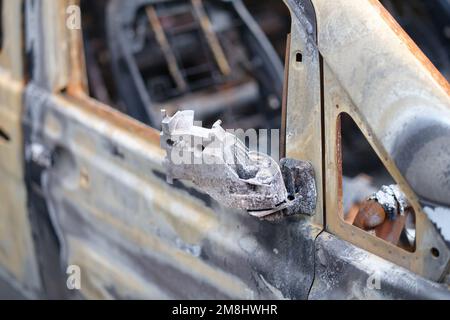 Burnt-out rusty cars on city street, vandalism Stock Photo