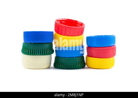 Different color bottle caps, excellent raw material for recycling. Composition with plastic bottles and caps isolated on white. Stock Photo