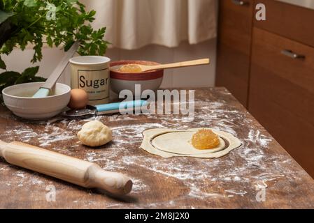 Puff pastry cut out and with angel hair or pumpkin candy on top, next to a rolling pin and a ball of puff pastry. Stock Photo