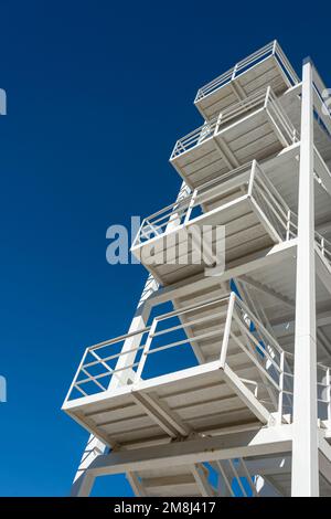 Steel staircase on the side of a building with a blue sky background Stock Photo