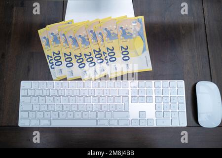 some 200 euro banknotes are lying next to a computer keyboard Stock Photo