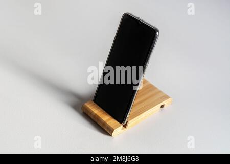 Mobile phone mounted on a special stand on a white background. Stock Photo