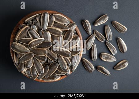 Black sunflower seeds in a bowl, on black background Stock Photo