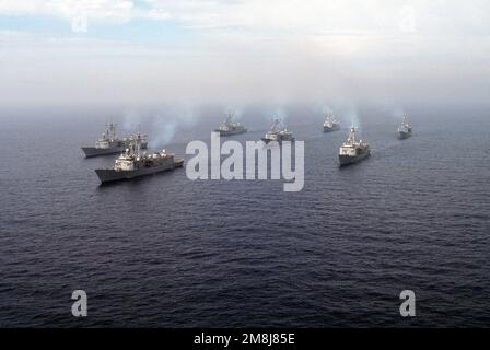 Destroyer Squadron One (DesRonOne) steaming in formation off the coast of San Clemente Island. The formation consists of seven FFG class ships of the Naval Reserve Force. From left to right, rear to front; left row (rear) USS SIDES (FFG-14), (front) USS MAHLON S. TISDALE (FFG-27), middle row (rear) USS DUNCAN (FFG-10) (center) USS COPELAND (FFG-25) (lead ship) USS LEWIS B. PULLER (FFG-23), right row (rear) USS GEORGE PHILIP (FFG-12) and (front) USS WADSWORTH (FFG-9). Country: Pacific Ocean (POC) Stock Photo