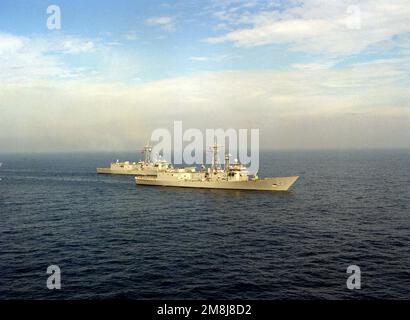 Destroyer Squadron One (DesRonOne) steaming in formation off the coast of San Clemente Island. The formation consists of seven FFG class ships of the Naval Reserve Force. From left to right, rear to front; left row (rear) USS SIDES (FFG-14), (front) USS MAHLON S. TISDALE (FFG-27), middle row (rear) USS DUNCAN (FFG-10) (center) USS COPELAND (FFG-25) (lead ship) USS LEWIS B. PULLER (FFG-23), right row (rear) USS GEORGE PHILIP (FFG-12) and (front) USS WADSWORTH (FFG-9). Country: Pacific Ocean (POC) Stock Photo