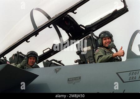 The thumbs up signal is given by LT. COL. Charlie Heald (front seat) and Peter Jennings of ABC News in the back seat of the F-15E Strike Eagle. The signal is given to notify everyone that everything is 'A' all right for the incentive flight to begin. Base: Seymour Johnson Air Force Base State: North Carolina (NC) Country: United States Of America (USA) Stock Photo