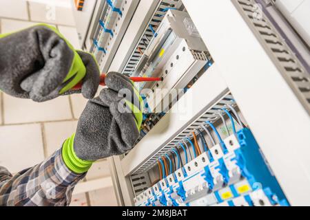 Electrician Finishing Electric Board Installation Close Up. Residential Electricity Fusebox. Stock Photo
