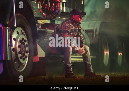 Relaxed Caucasian Truck Driver Seating on the Ground and Support His Back  on the Semi Truck Wheel Stock Photo - Alamy