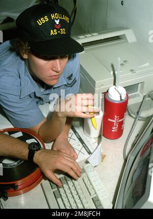 Data Processor Second Class (DP2) Bunni L. Kerstetter explains the analyzing process of the tape library to Data Processor SEAMAN Apprentice (DPSA) Glenn Arnold on board the submarine tender USS HOLLAND (AS-32). Country: Pacific Ocean (POC) Stock Photo