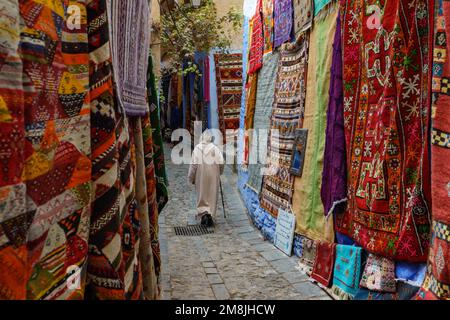 North Africa. Morocco. Chefchaouen. An old man dressed in a bournous walking in a street of the medina Stock Photo