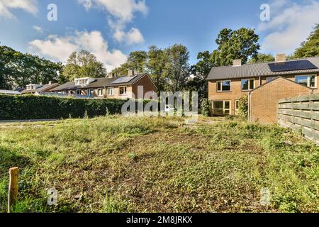 a house with solar panels on the roof and some trees in the back ground, looking towards the rear yard Stock Photo