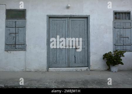 Facade of old house, vintage wooden door and window shutters Stock Photo