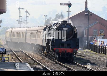 The British Railways built 92203 Black Prince 9F class locomotive pulls in at Toddington railway stations in the Cotswolds in Britain.  The Black Prin Stock Photo