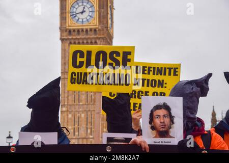 London, England, UK. 14th Jan, 2023. Protesters with hoods over their heads hold pictures of Guantanamo prisoners in Parliament Square. Activists wearing orange prison jumpsuits marched through Westminster calling for the Guantanamo Bay detention camp to be shut down. January 11th marked the 21st anniversary since the controversial prison opened. (Credit Image: © Vuk Valcic/ZUMA Press Wire) EDITORIAL USAGE ONLY! Not for Commercial USAGE! Credit: ZUMA Press, Inc./Alamy Live News Stock Photo