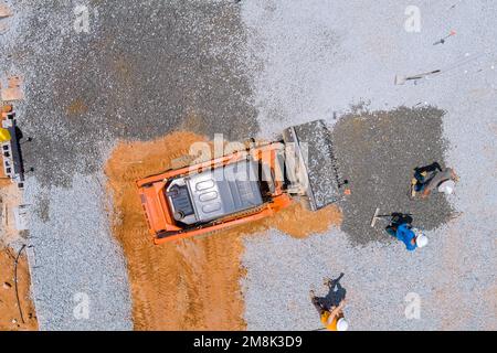 In construction site new building an excavator bucket is being used to level gravel before concrete foundation of building is poured. Stock Photo