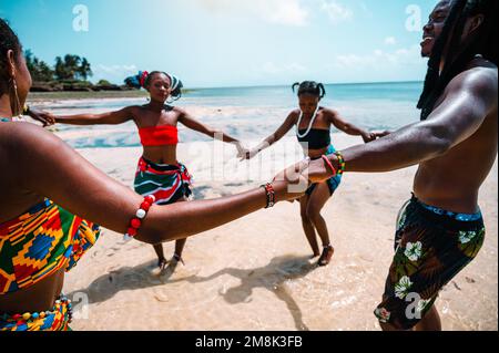 Local people with typical kenyan clothes dancing on the beach Stock Photo