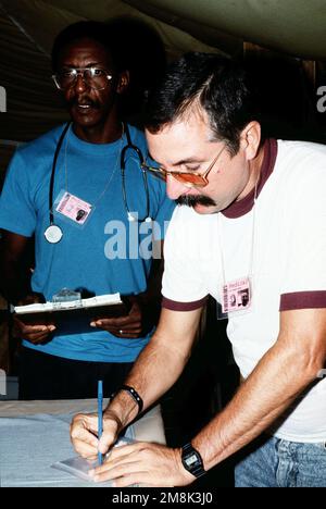 Two medical personnel prepare to give care to Cuban migrants. Military doctors accommodate the patients only when the Cuban doctors cannot provide the proper care. Subject Operation/Series: SEA SIGNAL V Base: Naval Station, Guantanamo Bay Country: Cuba (CUB) Stock Photo