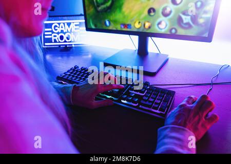 Professional cyber video gamer studio room with personal computer armchair, keyboard for stream in neon color blur background. Stock Photo