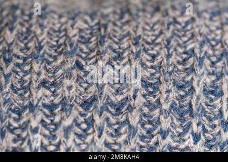 Hand knitted plaid. Geometric seamless knitted pattern. Knitted blue background, selective focus. Macro with shallow dof Stock Photo