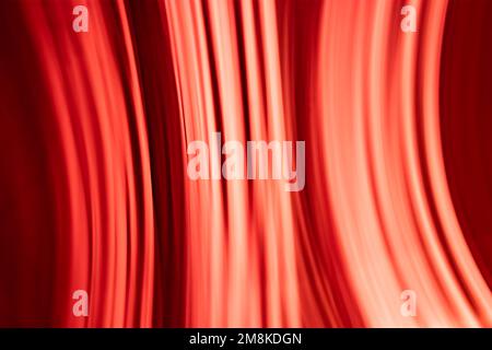 Abstract hot red background of rays and light in the form of vertical waves. Backdrop Stock Photo