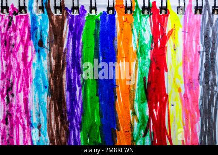 A sheet of notebook in stripes is shaded with multi-colored felt-tip pens. Background abstraction. Backdrop Stock Photo