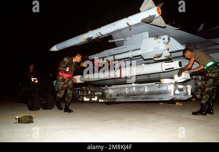 Weapon loaders rearm a US Air Force F-16C Fighting Falcon from the 23rd Fighter Squadron, Spangdahlem Air Base, Germany, in preparation for NATO airstrikes against the Bosnian Serbs. The aircraft is being rearmed with Sparrow and Sidewinder missiles. Subject Operation/Series: DELIBERATE FORCE Base: Aviano Air Base State: Pordenone Country: Italy (ITA) Stock Photo