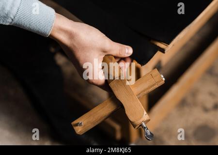Genuine leather belt creation process in production factory. The craftsman is cutting the belt genuine leather using cutter in the workshop Stock Photo