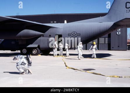 A crew of fire fighters from the 21st Civil Engineer Squadron's Fire Department respond to a simulated smoking C-130 aircraft on the flight line. They were participating in the 21st Space Wing's Operational Readiness Inspection that was conducted at Cheyenne Mountain Air Station and Peterson AFB, Colo., 13 to 17 February 1996. The Inspector General's Team tested their ability to respond to battle conditions, power outages, mobility deployments, aircraft and automobile accidents, hostage situations, bomb threats, armed robbery, terrorism, and communication disruptions. Base: Peterson Air Force