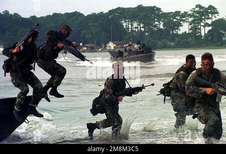 US Marines from Charlie Company, 1ST Battalion, 6th Marine Regiment, jump from a Rigid Raider Craft and rush toward the beach to assist in rescuing hostages during Exercise Preying Mantis II at Camp Lejeune, NC. Marines from Headquarters Battalion, 2ND Marine Division, conducted mass casualty drills, hostage rescue drills, and operations in support of Small Craft Units, during the exercise. Subject Operation/Series: PREYING MANTIS II Base: Marine Corps Base, Camp Lejeune State: North Carolina (NC) Country: United States Of America (USA) Stock Photo