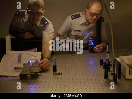 1LT Weist (left) and 1LT Hinkle set up a laser experiment in the Photonics Laboratory. First of the double exposure records the lieutenants and the equipment while the second captured the laser beam using CO2 gas to render the beam visible. Base: Rome Laboratory, Rome State: New York (NY) Country: United States Of America (USA) Stock Photo