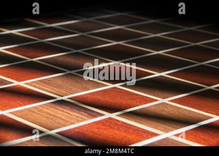 Shadows streak across a hand made checkered pattern of birch, maple, and mahogany wood to look like natural wood flooring or chess board. Stock Photo