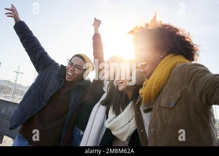 Group of excited young friends having fun together outdoor. Diverse people hug and laugh enjoy Stock Photo