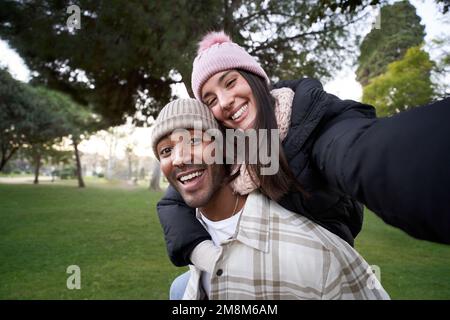 Portrait of happy young multiethnic couple taking a cheerful selfie. Beautiful girlfriend having fun Stock Photo
