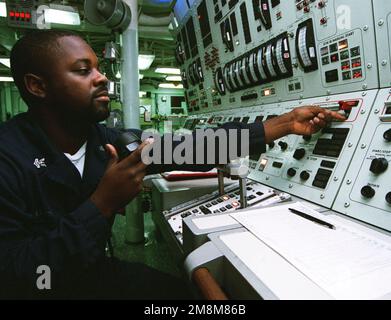 US Navy Gas Turbine Systems Technician (mechanical) Allen Brown monitors the Propulsion Auxiliary Control Console (PACC) within the Central Control Station (CCS), on board the US Navy's Ticonderoga class guided missile cruiser USS ANZIO (CG 68). Anzio is participating in an All Service Combat Identification Evaluation Team Exercise (ASCIET '96) off the coast of Gulfport, Mississippi. Subject Operation/Series: ASCIET '96 Base: USS Anzio (CG 68) Stock Photo
